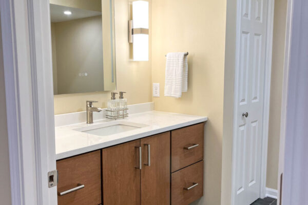 bathroom floating wood vanity and black tile floors